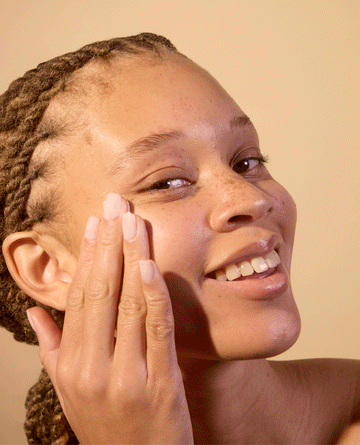 Woman applying Acure's moisturizer